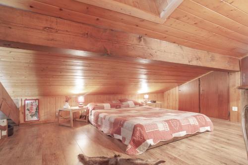 a bedroom with a bed in a wooden cabin at Tournette Montagnes et Lacs in Saint-Jean-de-Sixt