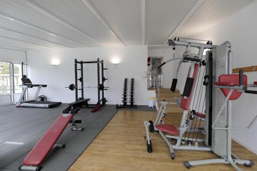 a gym with several tread machines in a room at Hotel Apartamentos Cala Santanyi in Cala Santanyi