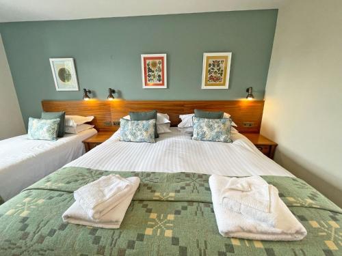 a bedroom with two beds with towels on them at The Ship in Parkgate