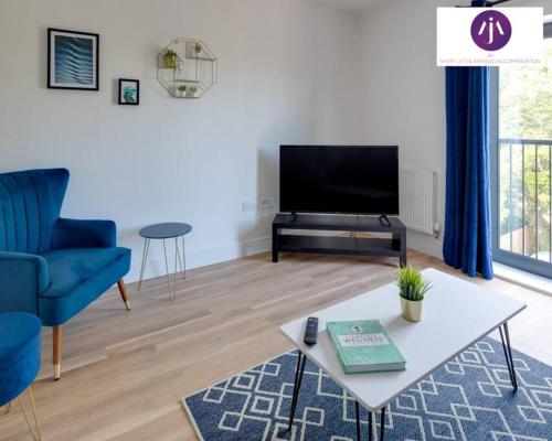 a living room with a blue couch and a tv at Stevenage Luxury 1Bed Apartment - Sleeps 4-WIFI-Free Parking- By JM Short Lets & Serviced Accommodation in Stevenage