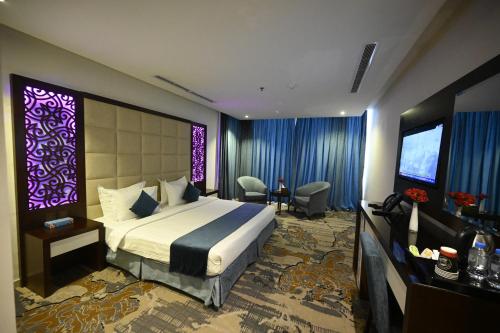 a hotel room with a bed and a purple screen at Aster Hotel in Jeddah