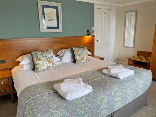 a bedroom with a large bed with towels on it at The Ship in Parkgate