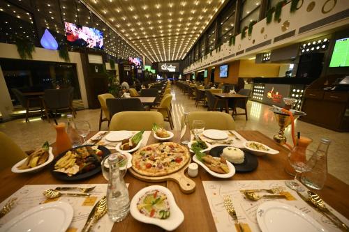 a table with plates of food and a pizza at Aster Hotel in Jeddah