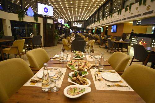 a long table in a restaurant with plates of food at Aster Hotel in Jeddah