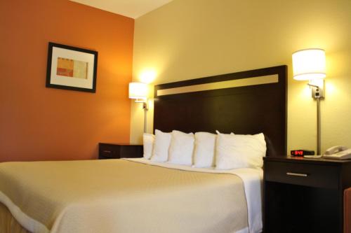 a hotel room with a large bed with white pillows at Days Inn by Wyndham Globe in Globe