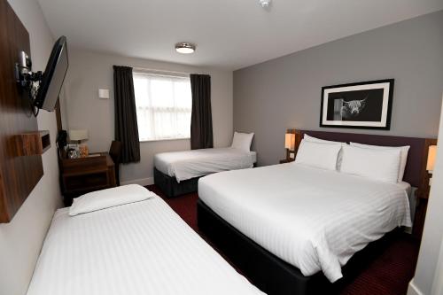 a hotel room with two beds and a window at Pine Marten, Dunbar by Marston's Inns in Dunbar