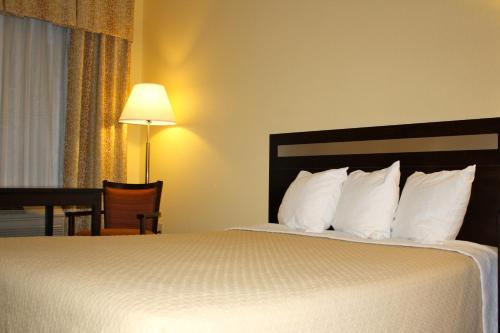 a hotel room with a large bed with white pillows at Days Inn by Wyndham Globe in Globe