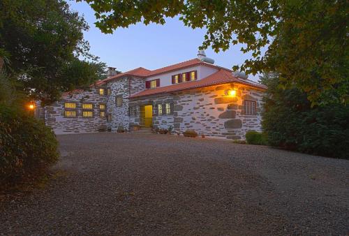a stone house with lights on a driveway at Quinta da Vargem in Unhais da Serra