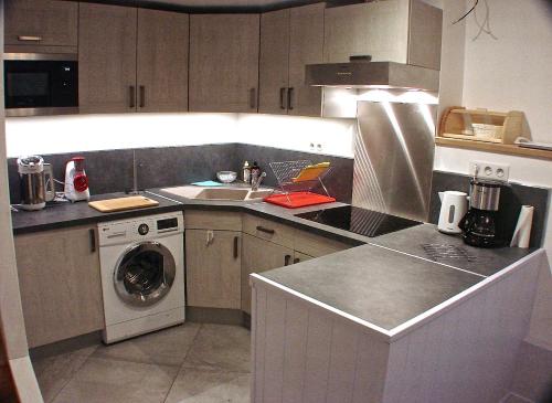 a kitchen with a sink and a washing machine at Villa Eth Mayouret in Cauterets