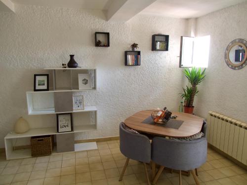 a dining room with a table and chairs and a shelf at Verdon Secret - L'escapade parfaite in Gréoux-les-Bains
