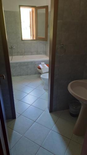 Villagrande StrisailiにあるFattoria Nuraghe Murtarbaのバスルーム(トイレ、バスタブ、シンク付)