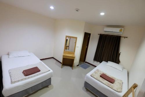 a bedroom with two beds and a mirror in it at Phi Phi Blue Lagoon in Phi Phi Don