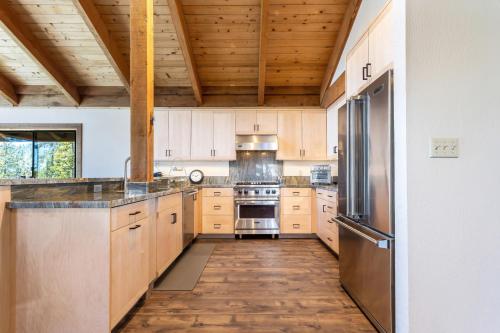 cocina grande con armarios de madera y electrodomésticos de acero inoxidable en Beautiful Remodel with Chef's Kitchen - Sky High #14, en Bear Valley