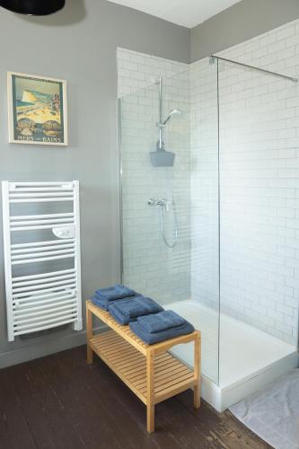 a bathroom with a shower with a blue seat at La maison au fil du temps in Pont-Rémy