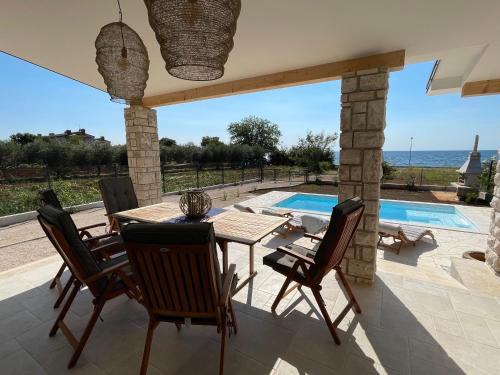 een patio met een tafel en stoelen en een zwembad bij Casa Giovanna in Umag