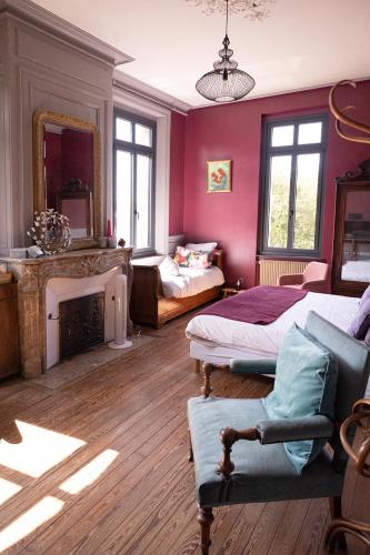 a living room with two beds and a fireplace at La maison au fil du temps in Pont-Rémy