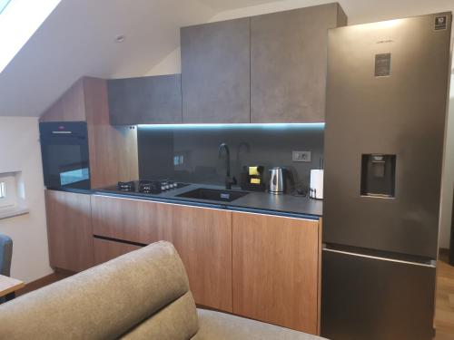 eine Küche mit einem Kühlschrank aus Edelstahl und einer Spüle in der Unterkunft Nibela Apartments in Zagreb