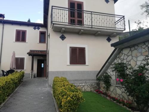 a white building with a balcony and a yard at Il Roseto in Coppito