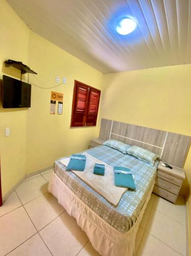 a bedroom with a bed with blue pillows on it at Pousada e Chalés Recantos do Mar in Barra Grande