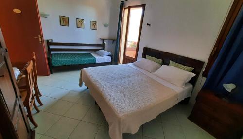 Villagrande StrisailiにあるFattoria Nuraghe Murtarbaのベッドルーム(大型ベッド1台、窓付)