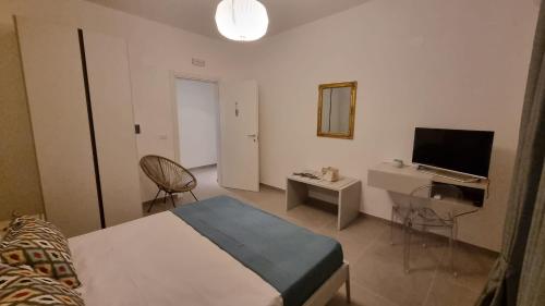 a bedroom with a bed and a desk and a television at Maison D’aMi’ in Termoli