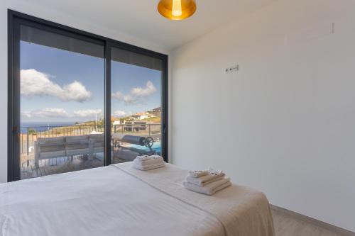 een slaapkamer met een bed en uitzicht op de oceaan bij Casa Mozart I in Estreito da Calheta