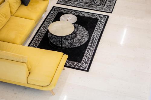 un sofá amarillo y una mesa en la sala de estar en Hotel Philippos, en Volos