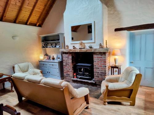 sala de estar con sofá y chimenea en Carraun Cottage, en Manorhamilton