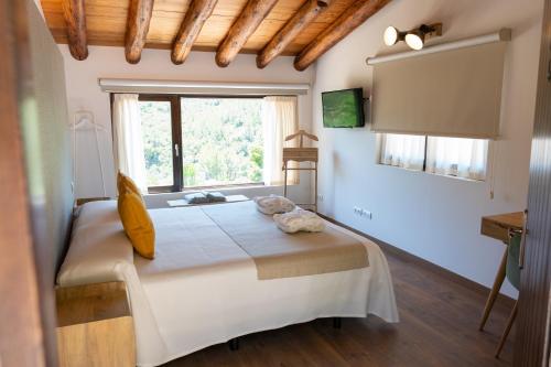 a bedroom with a large bed with a window at Hotel Mas Mariassa in Pratdip