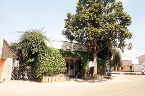 un edificio con un albero di fronte di La paillotte gorilla place kinigi a Kinigi