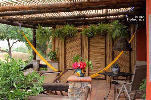 a pergola with a table and flowers on a patio at La Casa del Guamúchil in Tequesquitengo