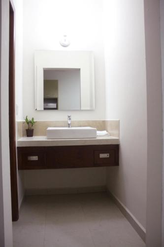 a bathroom with a sink and a mirror at MARENA Suites & Apartments in Mazatlán