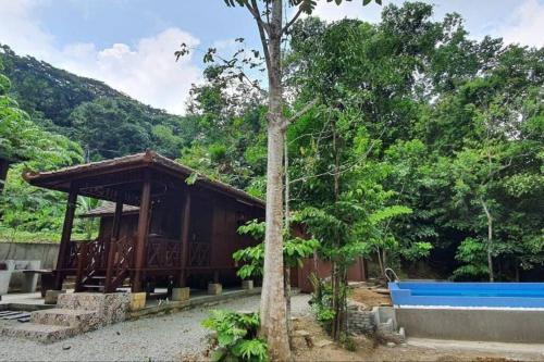 a building with a tree in front of it at THE DENAI Langkawi in Kuah