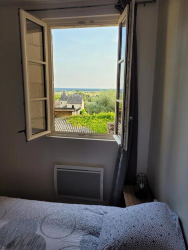 1 dormitorio con cama y ventana con vistas en la petite montagne, en Le Puy-Notre-Dame