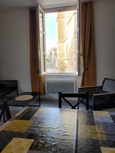 un salon avec une table et une fenêtre dans l'établissement la petite montagne, à Le Puy-Notre-Dame