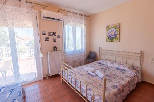 a bedroom with a bed and a large window at Marathos Sea View Apartments in Marathos