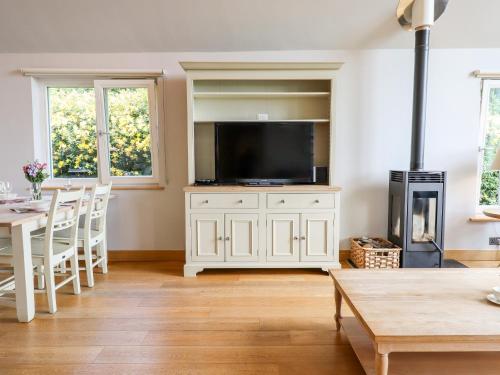 a living room with a television and a table and chairs at Swandown, 12 Kittwhistle in Chard