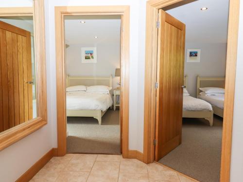 a door leading to a bedroom with two beds at Swandown, 12 Kittwhistle in Chard