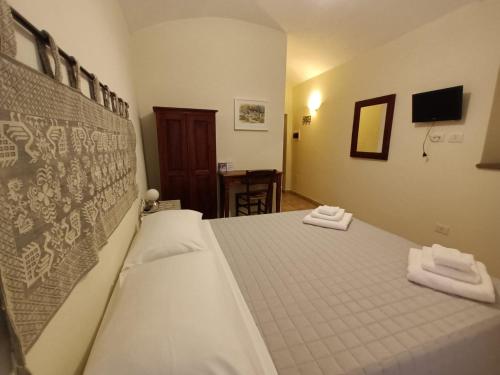 a bedroom with a bed with two towels on it at La Vecchia Torre in Bosa