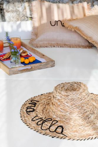 un cappello di paglia seduto accanto a un vassoio di cibo di Una Villa - Amalfi Boutique Rooms B&B ad Amalfi