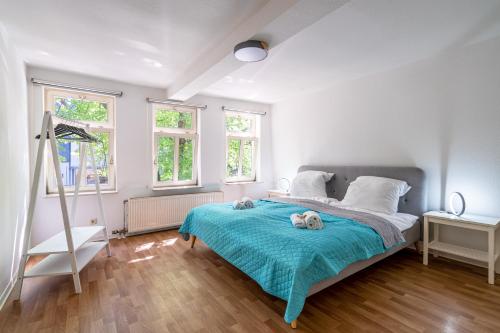 弗里德貝格的住宿－Stylische 2-Zimmer Wohnung - Balkon - Parkplatz - Smart TV - Arbeitsplatz，卧室配有一张睡床,床上有两只填充的动物,放在蓝色的毯子上