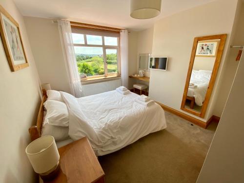 een slaapkamer met een wit bed en een spiegel bij Mooredge B&B in Whitby