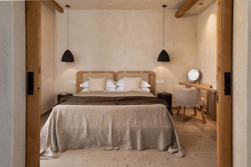 a bedroom with a large bed and a desk at Opuntia Suites in Naxos Chora