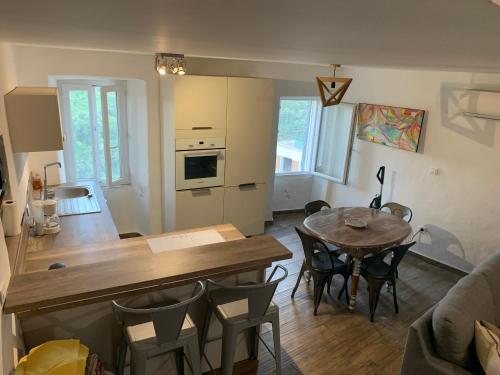 a kitchen and living room with a table and a dining room at Maison en Pierre - Proche de la Mer in Castellare-di-Casinca