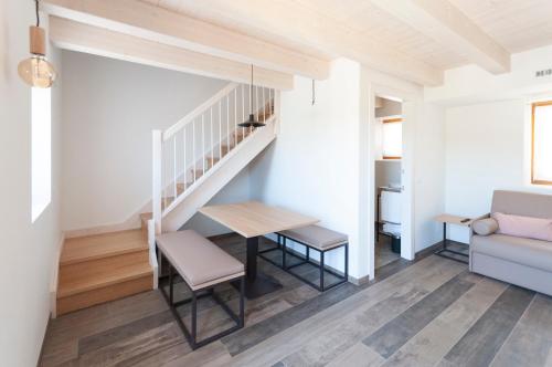a living room with a table and a staircase at Tenuta Della Casa Wine & Rooms - La Pausa del Collio in Cormòns
