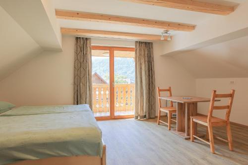 1 dormitorio con cama, mesa y ventana en Apartments Mulej, en Bled