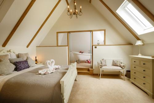 a attic bedroom with a bed and a bathroom at Honeysuckle Cottage in Thornham Magna