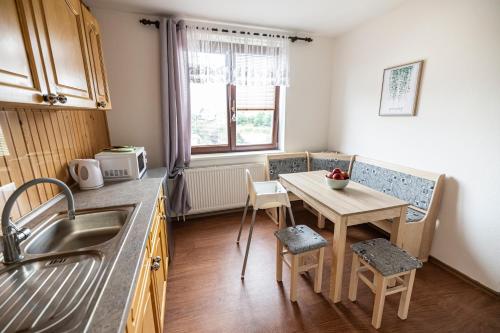 a kitchen with a table and a small table with chairs at Apartmán Absolon in Blansko