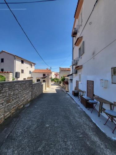 an alley with a table and benches next to a building at Studio Prommontore in Premantura