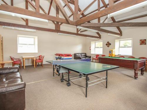 a room with a ping pong table and chairs at No 51 Valley Lodges in Callington